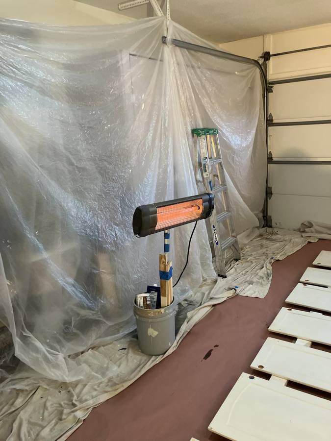 Garage set up as a plastic-sheeted spray area with a heater